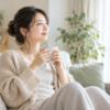 自宅のソファでマグカップを持ち、休む女性（AI生成画像）