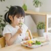 食卓に並んだ幼児食を前に座る2歳ごろの子ども