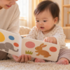 親子で絵本を眺める赤ちゃん（AI生成イメージ）