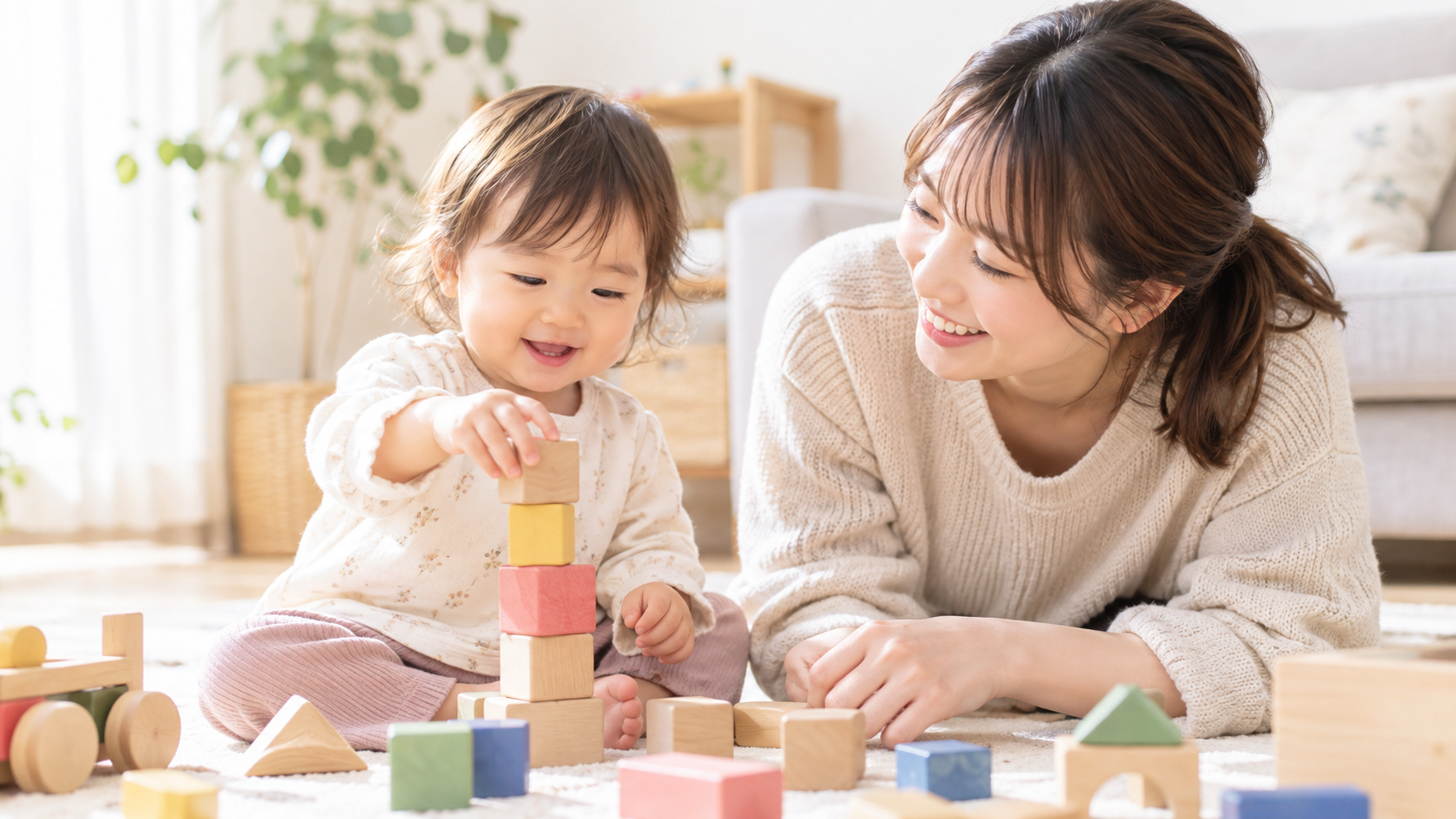 1歳くらいの女の子がお母さんと一緒に木製の積み木で遊んでいる様子